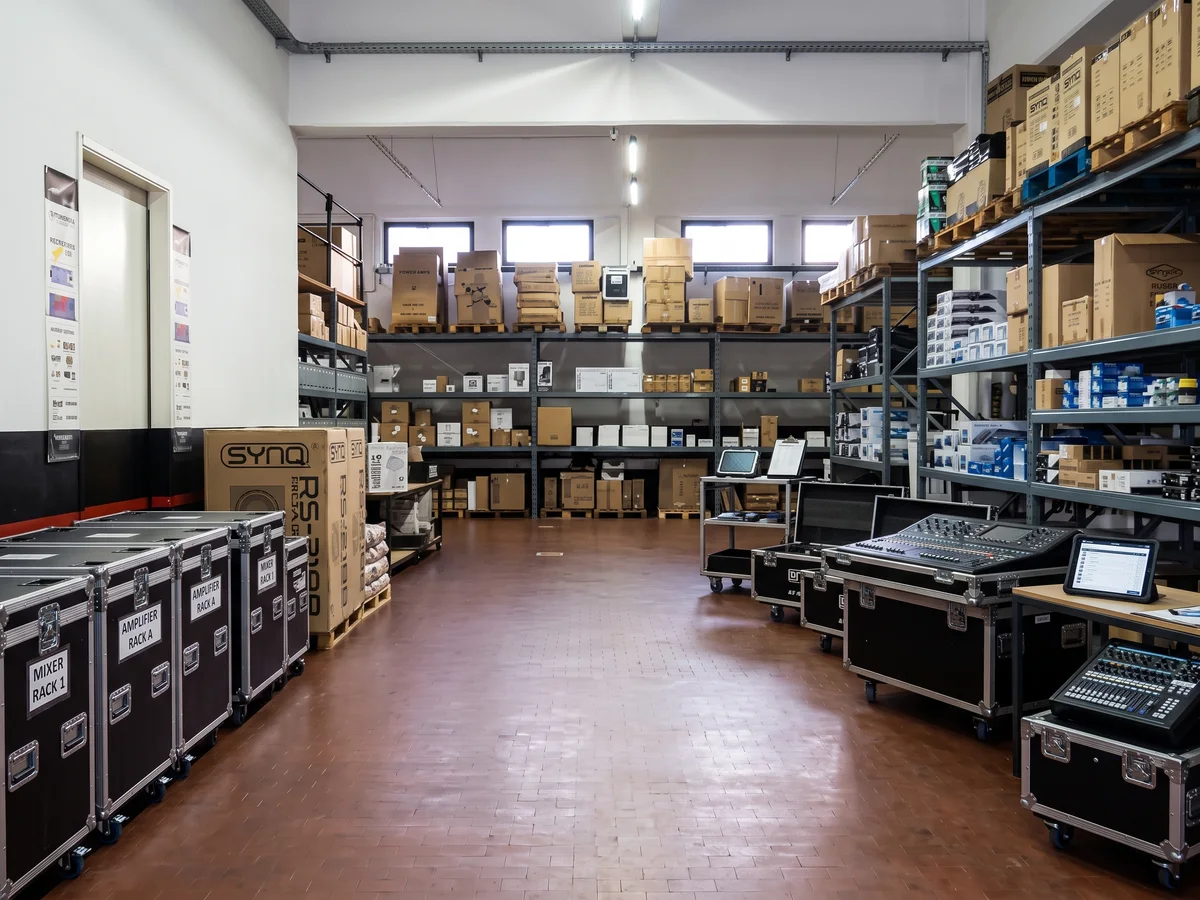 Visual di magazzino con scaffali, flight case e attrezzature audio-video