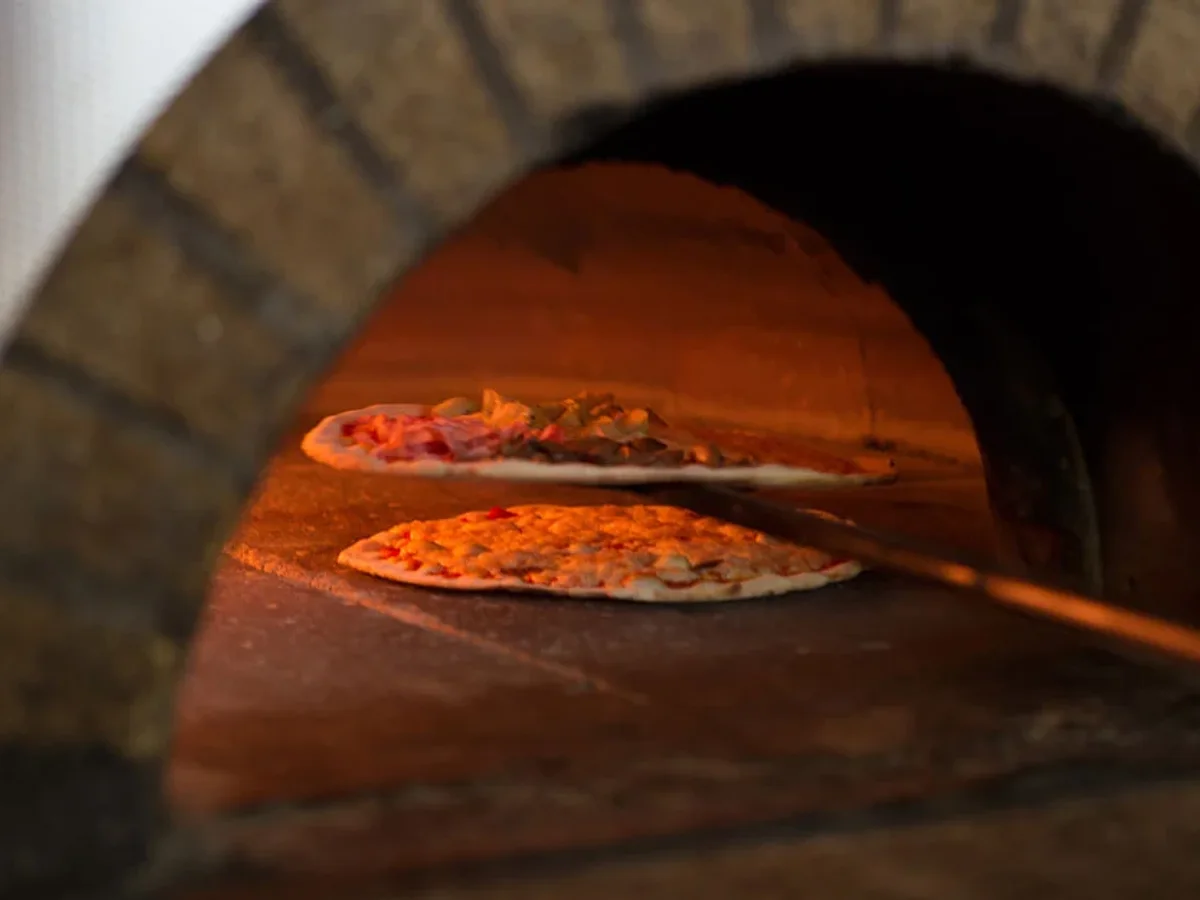 Pizze nel forno a legna di L’Angolo, nella fotografia di apertura del sito